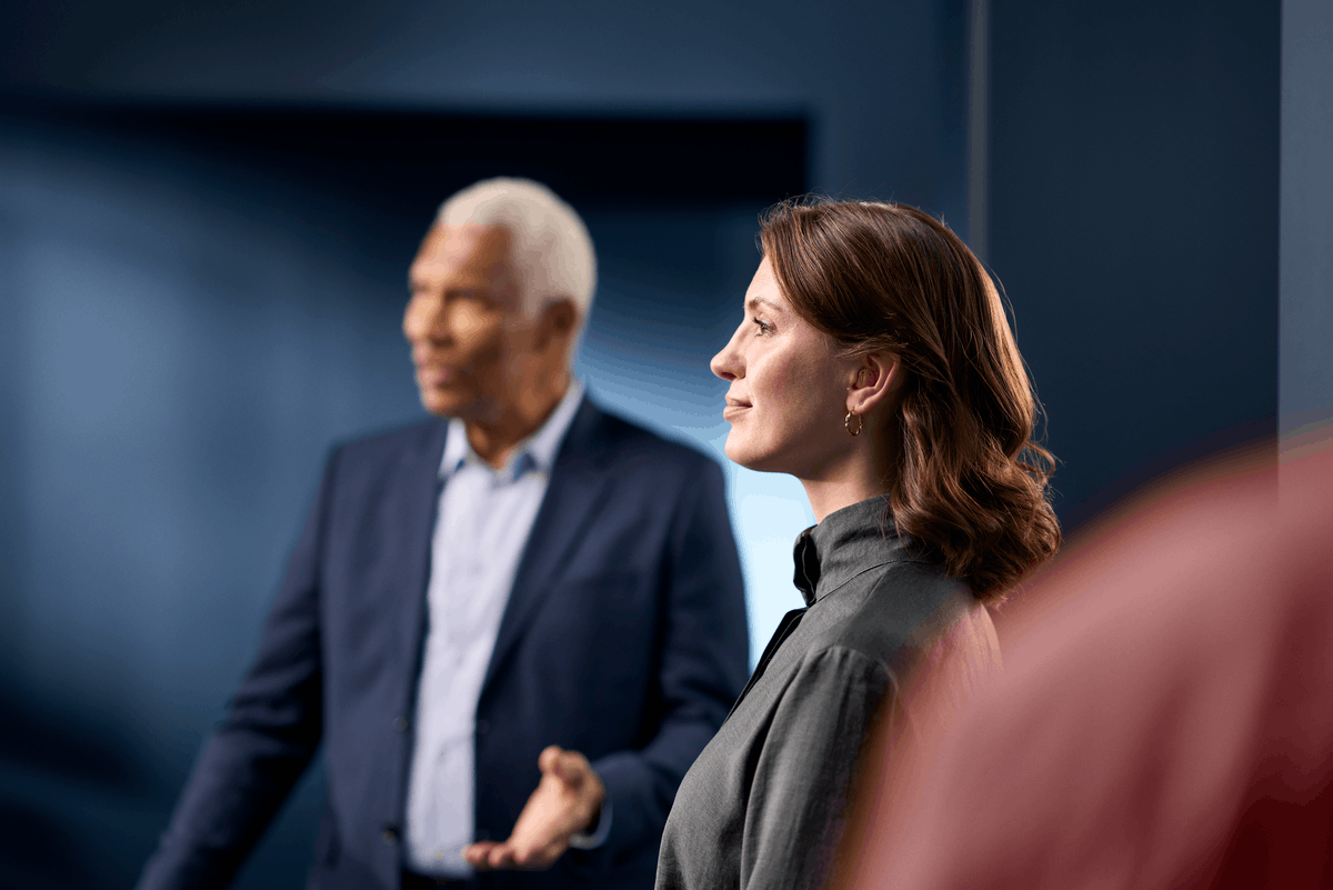 Close-up of a woman wearing a ReSound Savi ITC hearing aid as she engages in a conversation, showcasing the ability to hear conversations in noisy situations.