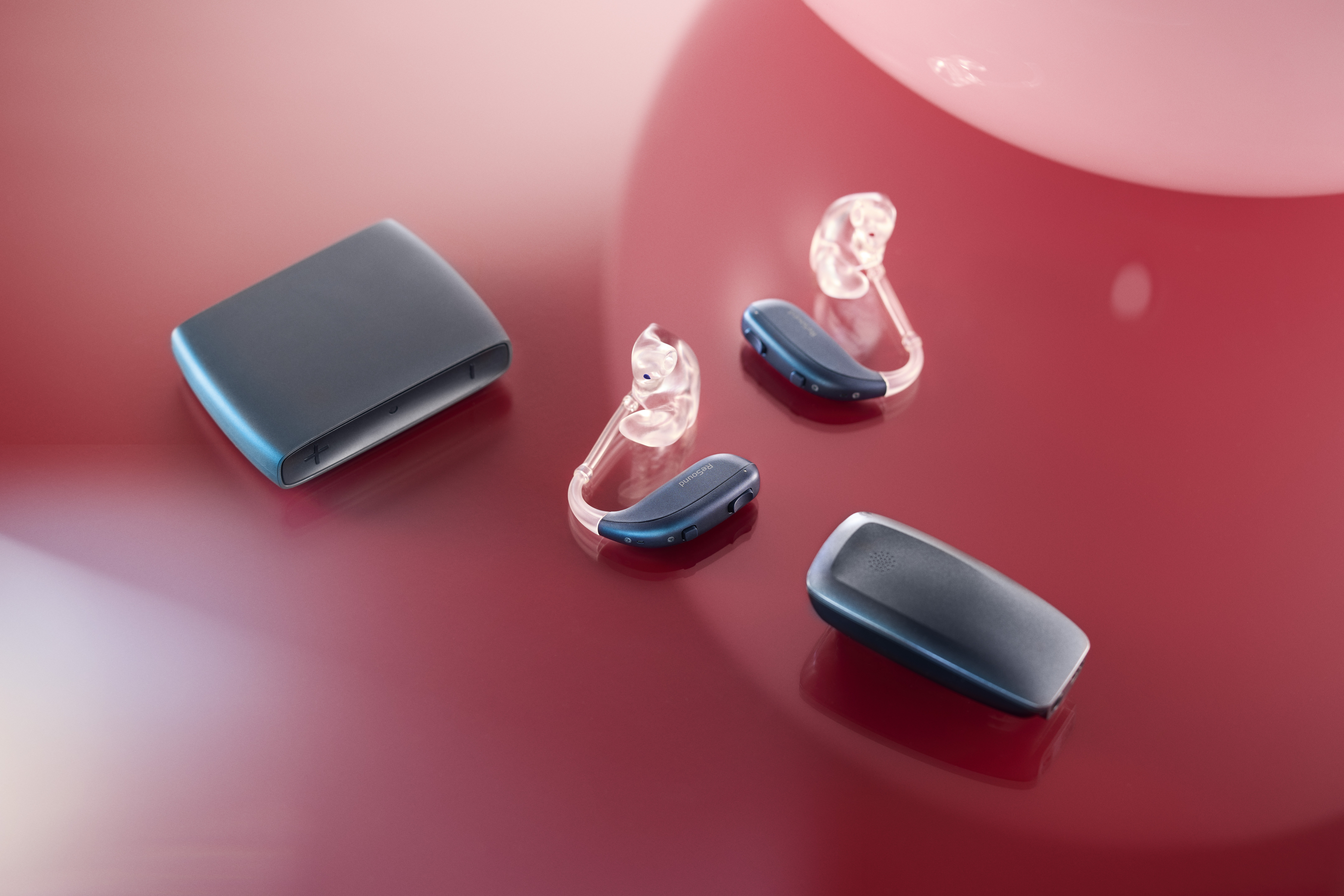 ReSound Accessories and Hearing Aids showcased on a Red Background